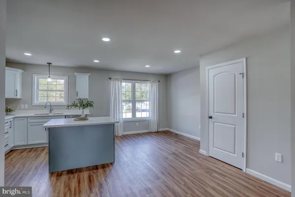 a kitchen with kitchen island wooden floors and stainless steel appliances