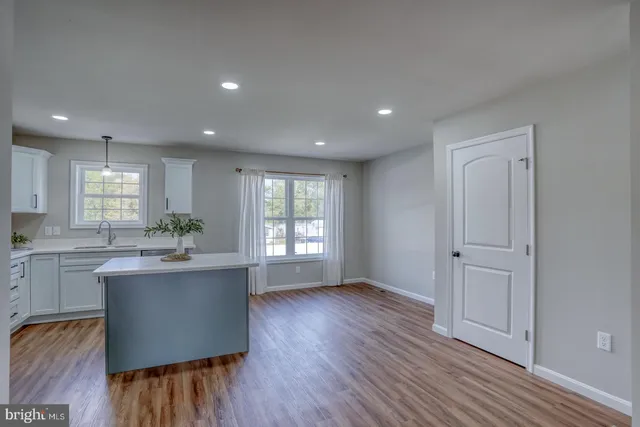 a kitchen with kitchen island wooden floors and stainless steel appliances