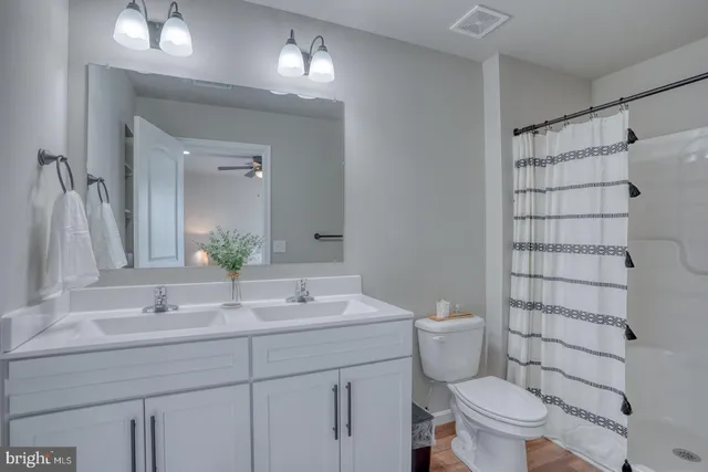 a bathroom with a sink a toilet a shower and a mirror