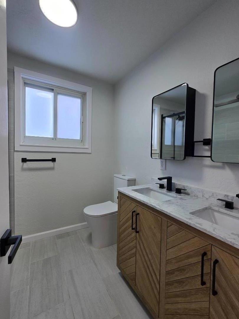 131 Hazel Avenue Millbrae, CA 94030 - Photo 13 of 19 a bathroom with a toilet sink and mirror