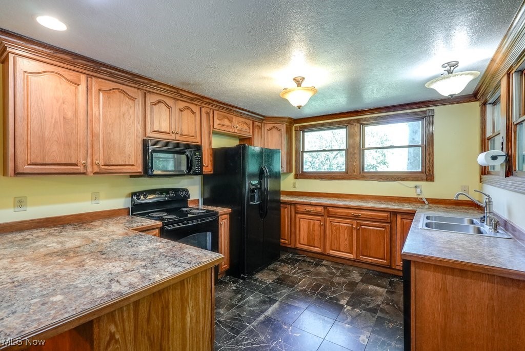 12802 Clinton Road Doylestown, OH 44230 - Photo 29 of 49 Kitchen featuring black appliances, ornamental molding, sink, and a textured ceiling