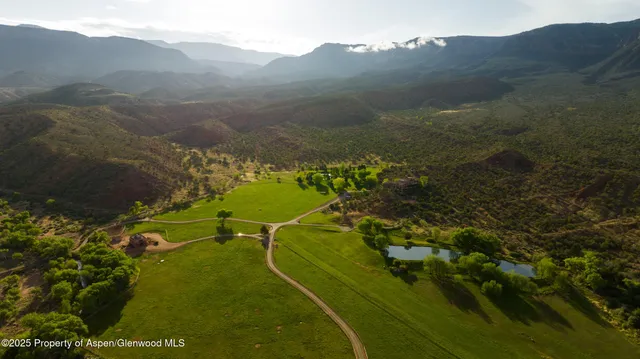 a view of a grassy field with mountains in the background