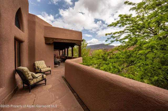 a living room with furniture a rug and a floor to ceiling window
