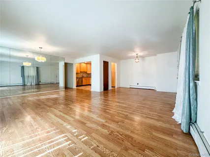 an empty room with wooden floor and natural light
