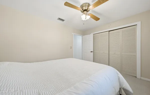 a view of a bedroom with a white bed and a chandelier