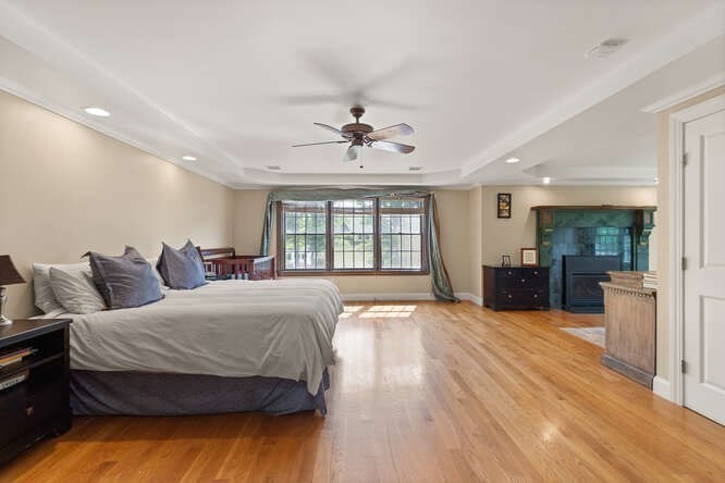 343 Bay Road Hamilton, MA 01982 - Photo 21 of 34 a spacious bedroom with a large bed and a chandelier