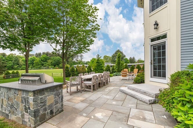 343 Bay Road Hamilton, MA 01982 - Photo 30 of 34 a view of a patio with a dining table and chairs with a fire pit