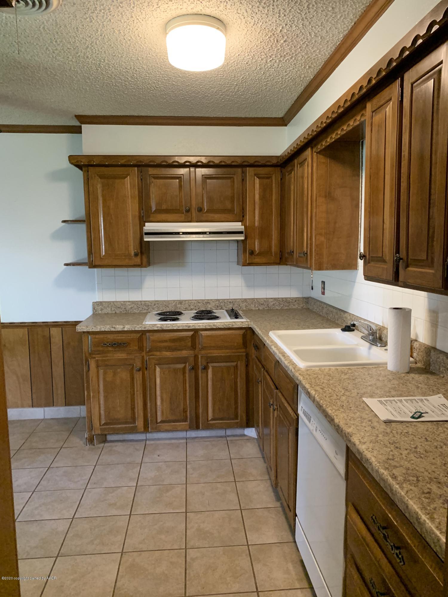 4406 Ridgecrest Circle Amarillo, TX 79109 - Photo 5 of 12 a kitchen with a sink a stove and cabinets