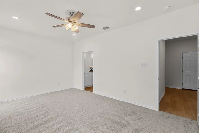 a view of an empty room with a ceiling fan