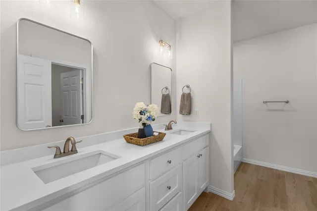 a bathroom with double vanity sink with mirror