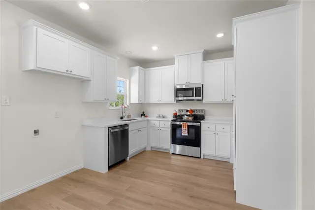 a kitchen with stainless steel appliances granite countertop a refrigerator and a stove top oven