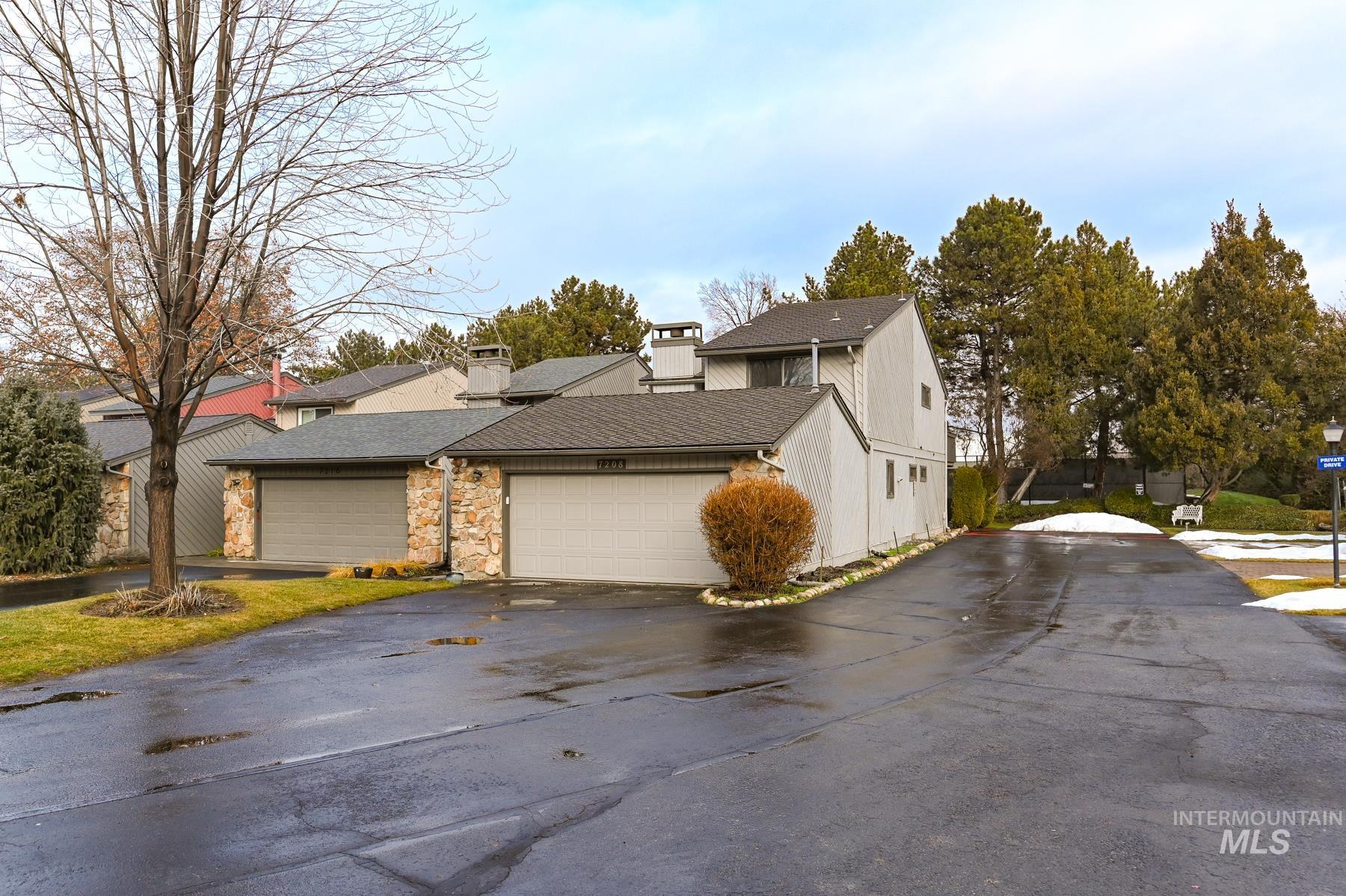 7208 West Cascade Street Boise, ID 83704 - Photo 44 of 49 View of home's exterior with a chimney, stone siding, driveway, roof with shingles, and a garage
