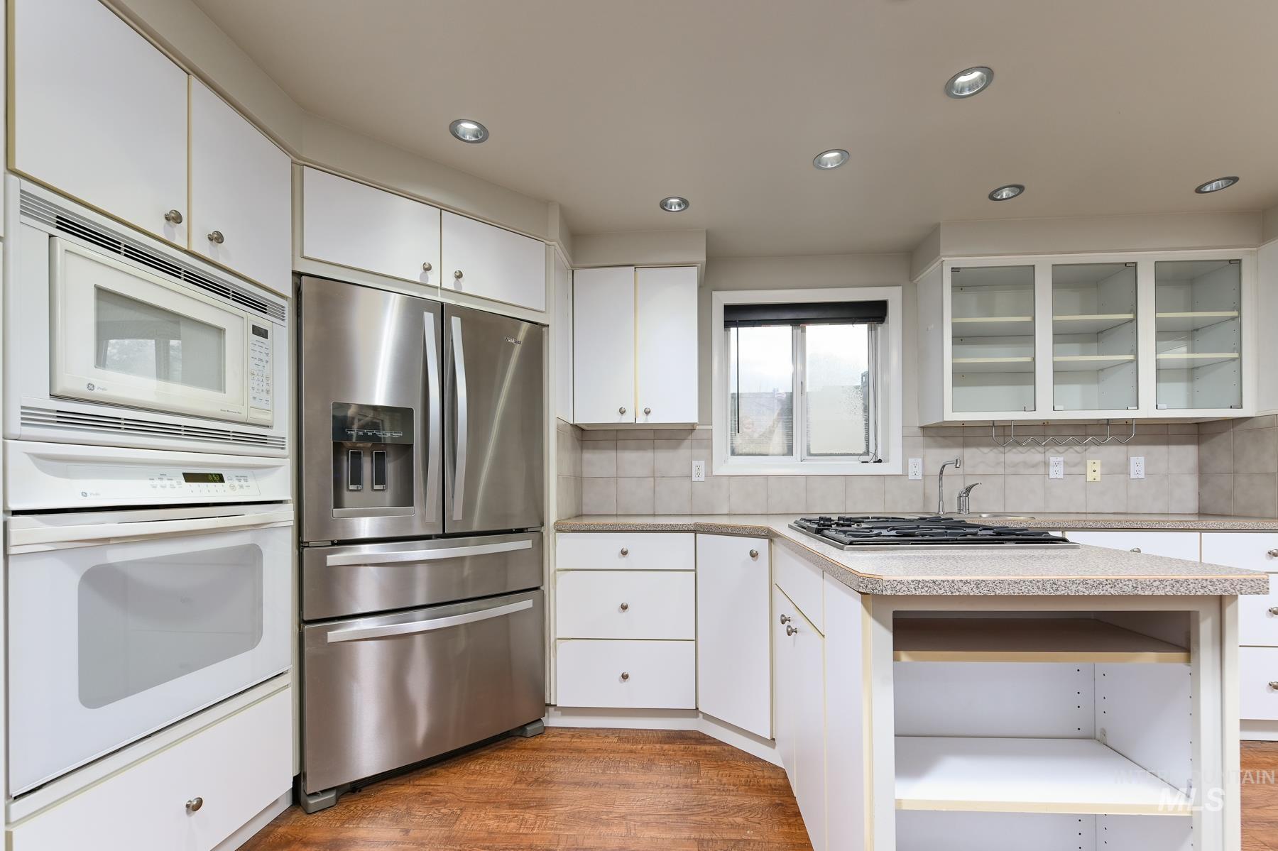 7208 West Cascade Street Boise, ID 83704 - Photo 9 of 49 Kitchen with open shelves, white appliances, glass fronted cabinets, white cabinetry, and recessed lighting