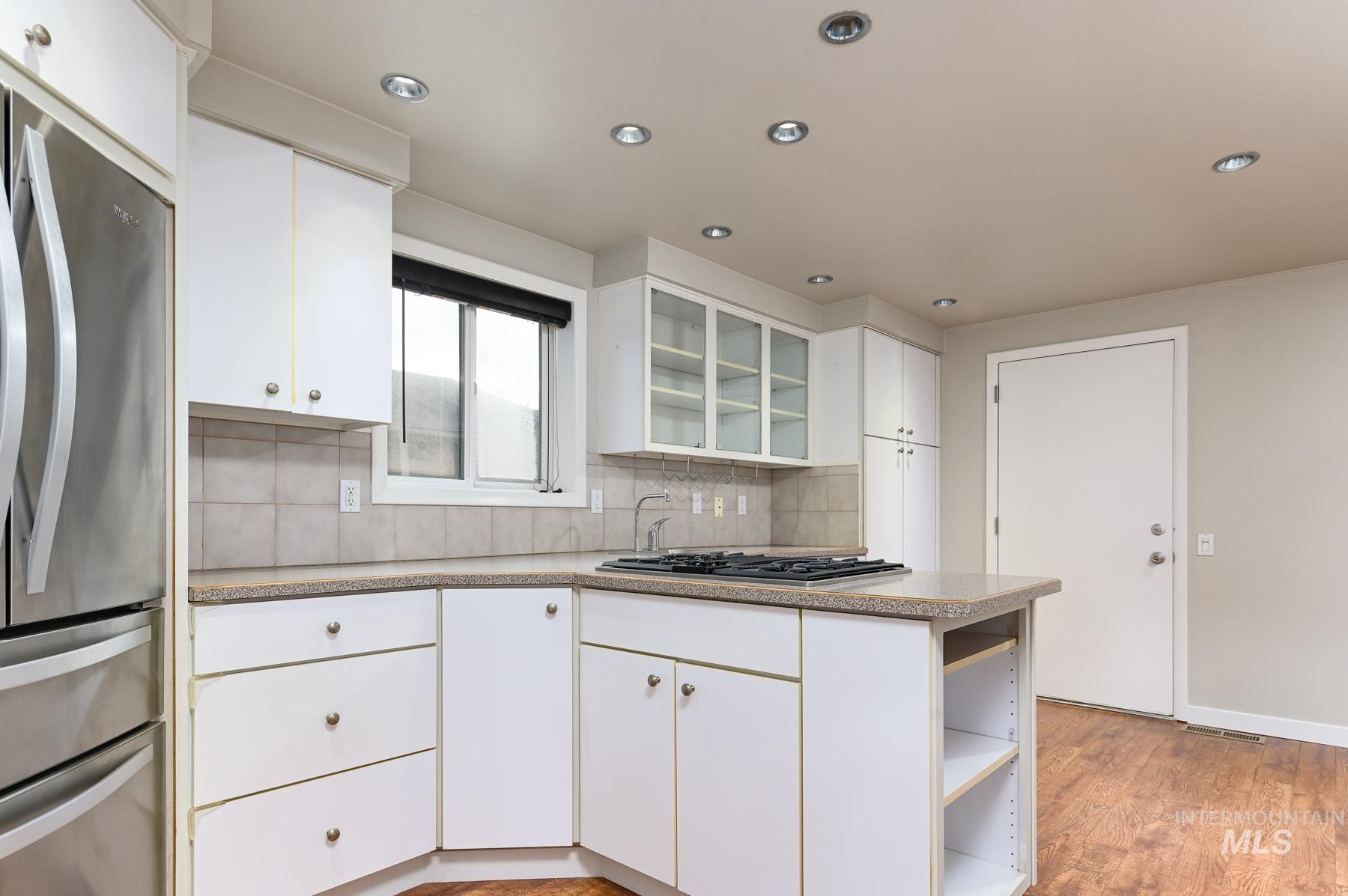 7208 West Cascade Street Boise, ID 83704 - Photo 10 of 49 Kitchen featuring glass fronted cabinets, stainless steel appliances, white cabinets, tasteful backsplash, and open shelves