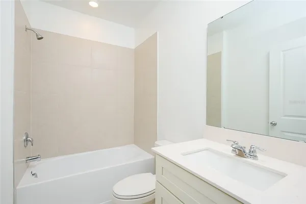 a bathroom with a bathtub shower sink vanity and toilet