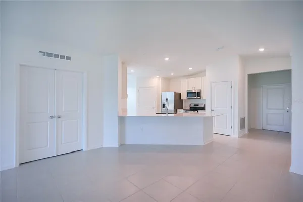 a large white kitchen with kitchen island a sink a stove and a refrigerator