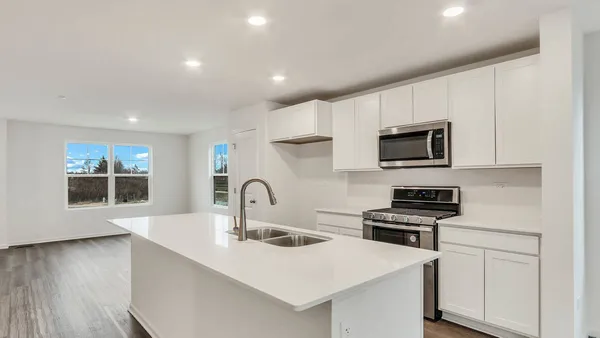 a kitchen with stainless steel appliances a stove microwave and sink