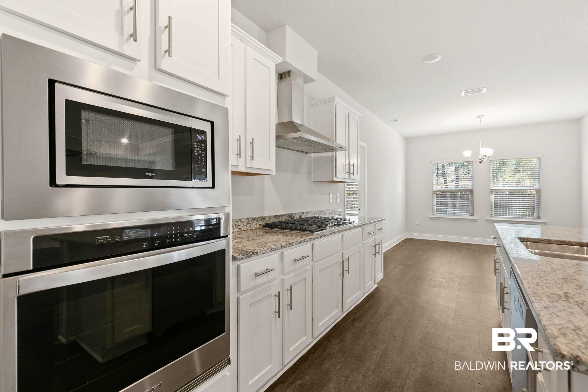 9448 Amethyst Drive Daphne, AL 36526 - Photo 18 of 61 Kitchen with stainless steel appliances, white cabinetry, dark wood-type flooring, and suspended lighting