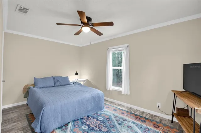 a bedroom with a bed and wooden floor
