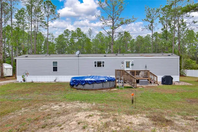 a view of a house with backyard and a tree