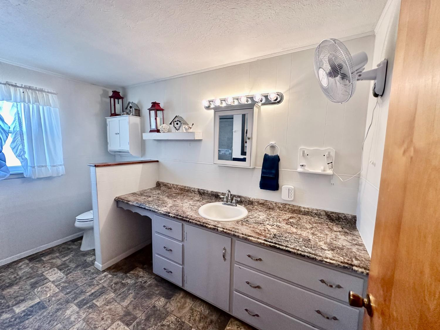615 Highway 84 Friona, TX 79035 - Photo 15 of 41 a bathroom with a granite countertop sink a mirror and vanity