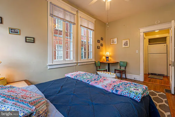 a bedroom with a bed and a window with chair