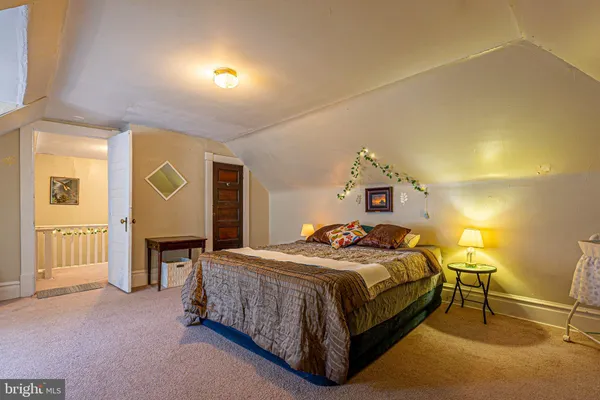 a spacious bedroom with a bed and a chandelier