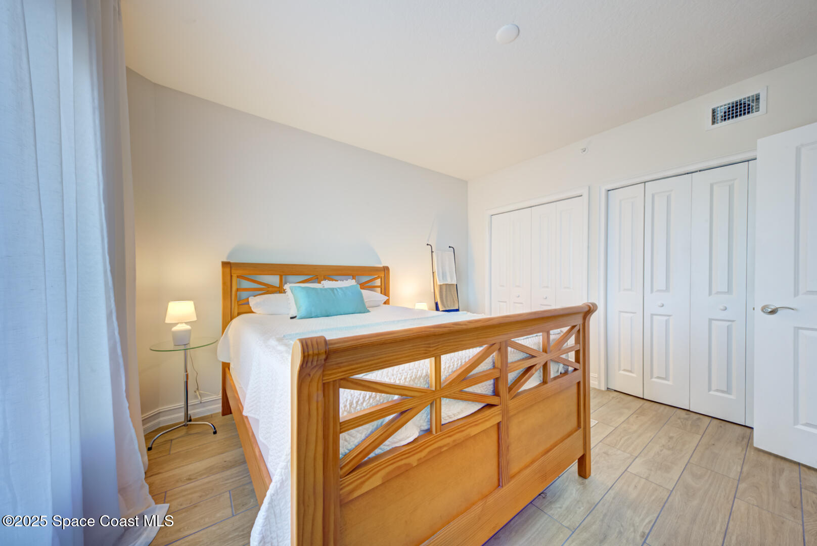 1805 Riverside Drive, Unit 504 Titusville, FL 32780 - Photo 18 of 48 a bedroom with a bed and wooden floor