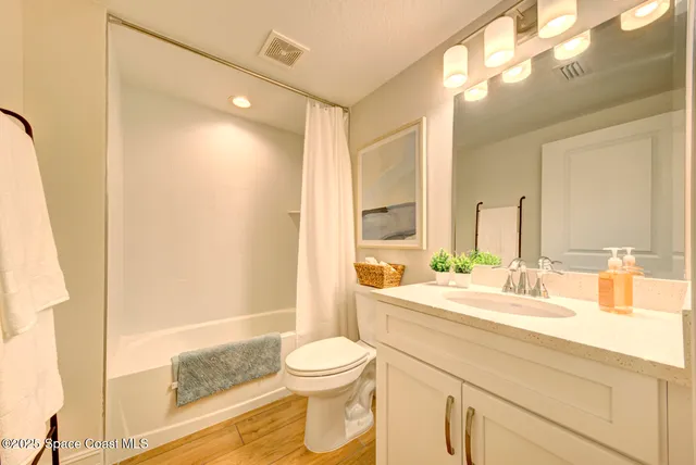 a bathroom with a granite countertop sink mirror vanity and toilet