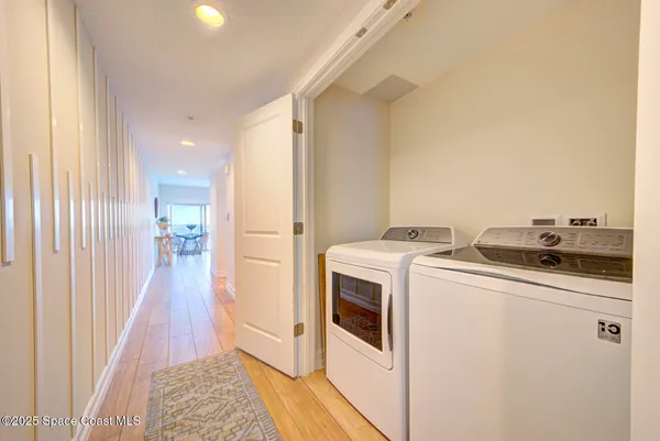 a view of washer and dryer with kitchen in the background