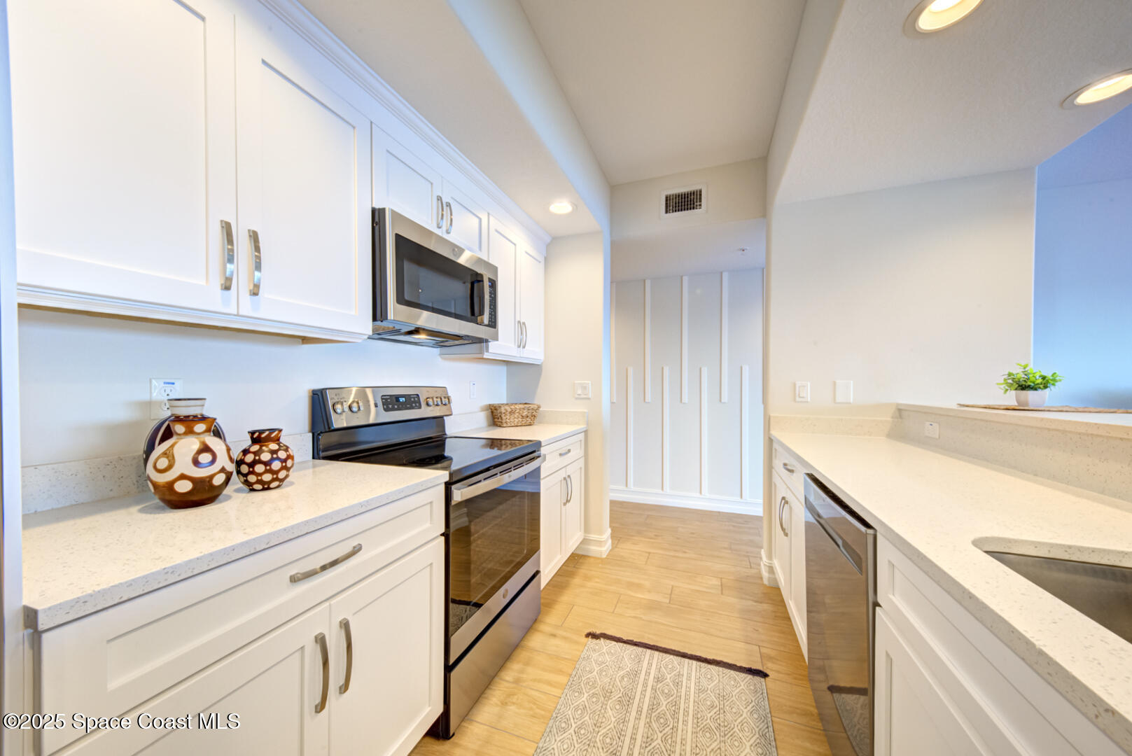 1805 Riverside Drive, Unit 504 Titusville, FL 32780 - Photo 25 of 48 a kitchen with stainless steel appliances white cabinets and a stove top oven