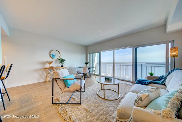 a living room with furniture and a floor to ceiling window