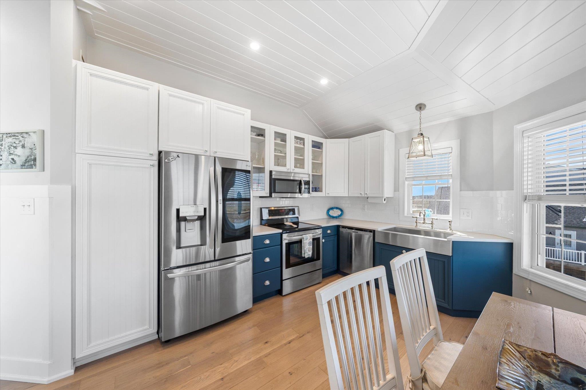 11 Leonard's Lane Avalon, NJ 08202 - Photo 24 of 34 a kitchen with stainless steel appliances granite countertop a refrigerator a stove a sink dishwasher a dining table and chairs with wooden floor