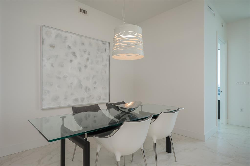 111 South Pineapple Avenue, Unit 1013 Sarasota, FL 34236 - Photo 14 of 62 a view of a dining room with furniture and wooden floor