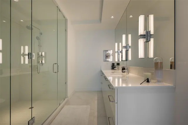 a bathroom with a double vanity sink a mirror and a shower