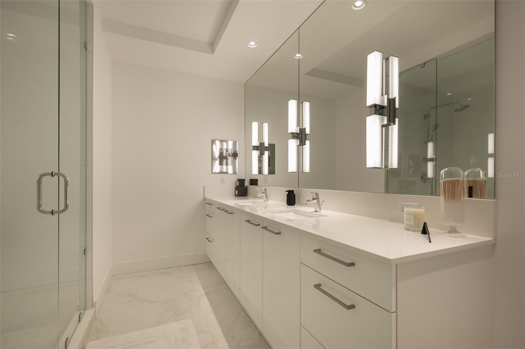 111 South Pineapple Avenue, Unit 1013 Sarasota, FL 34236 - Photo 21 of 62 a bathroom with a double vanity sink a mirror and a shower