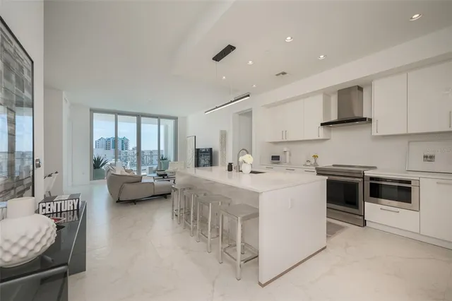a living room with furniture floor to ceiling window and a flat screen tv