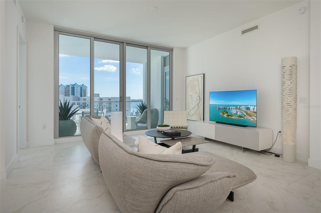 111 South Pineapple Avenue, Unit 1013 Sarasota, FL 34236 - Photo 7 of 62 a living room with furniture floor to ceiling window and a flat screen tv