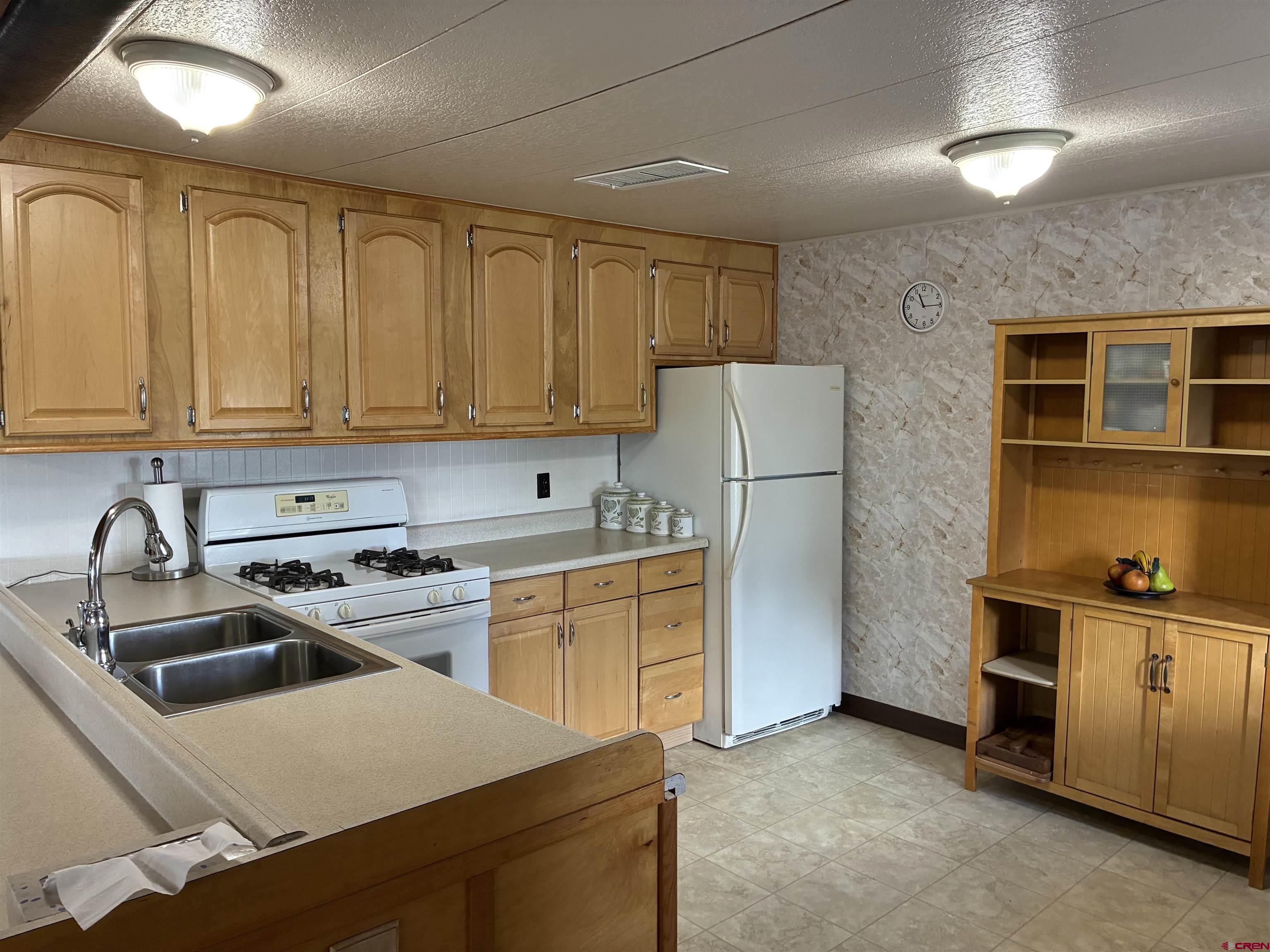 20806 County Road West Sanford, CO 81151 - Photo 17 of 24 a kitchen with a sink a stove and refrigerator
