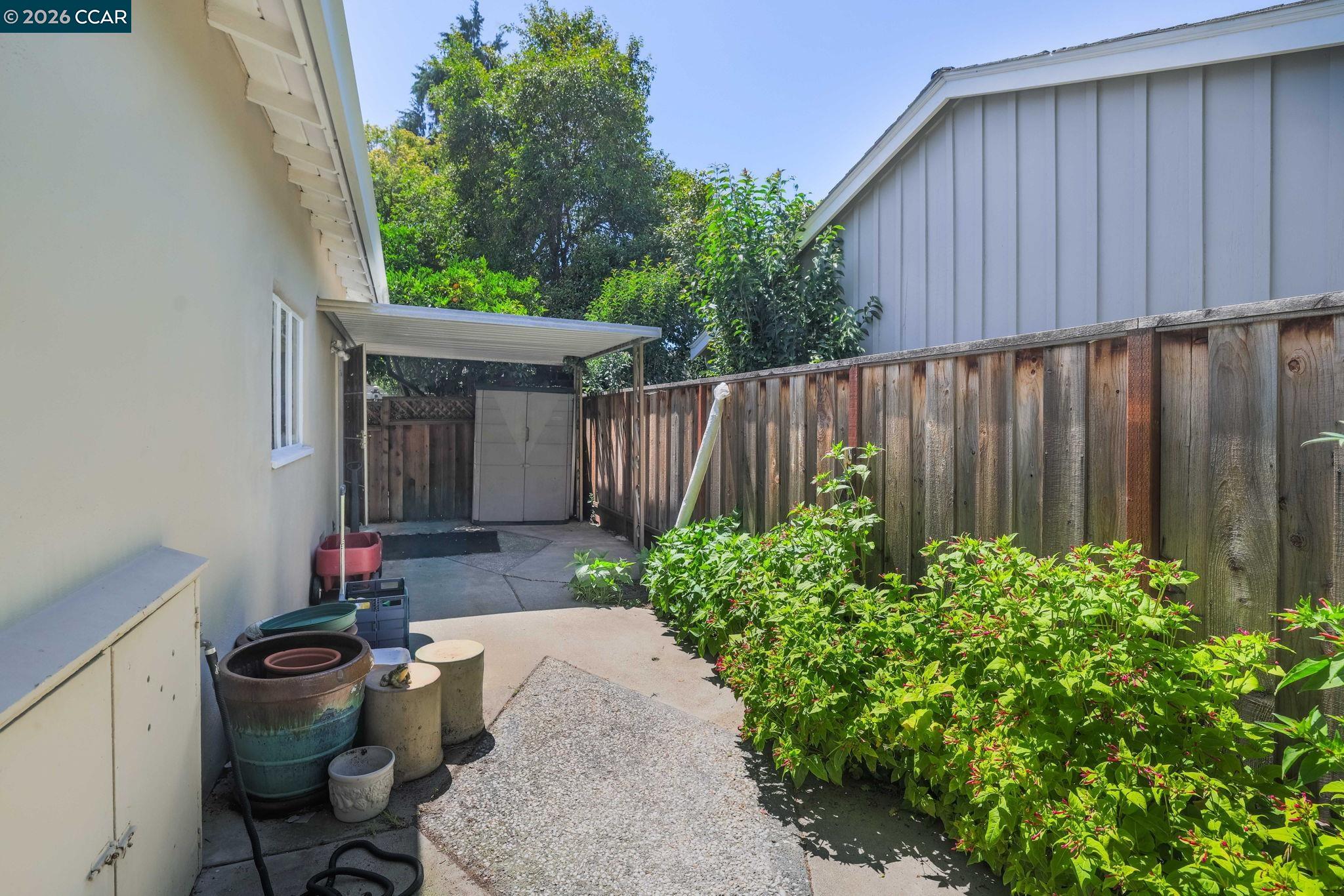 1051 San Rafael Street San Leandro, CA 94577 - Photo 9 of 26 a view of a backyard with potted plants and wooden fence