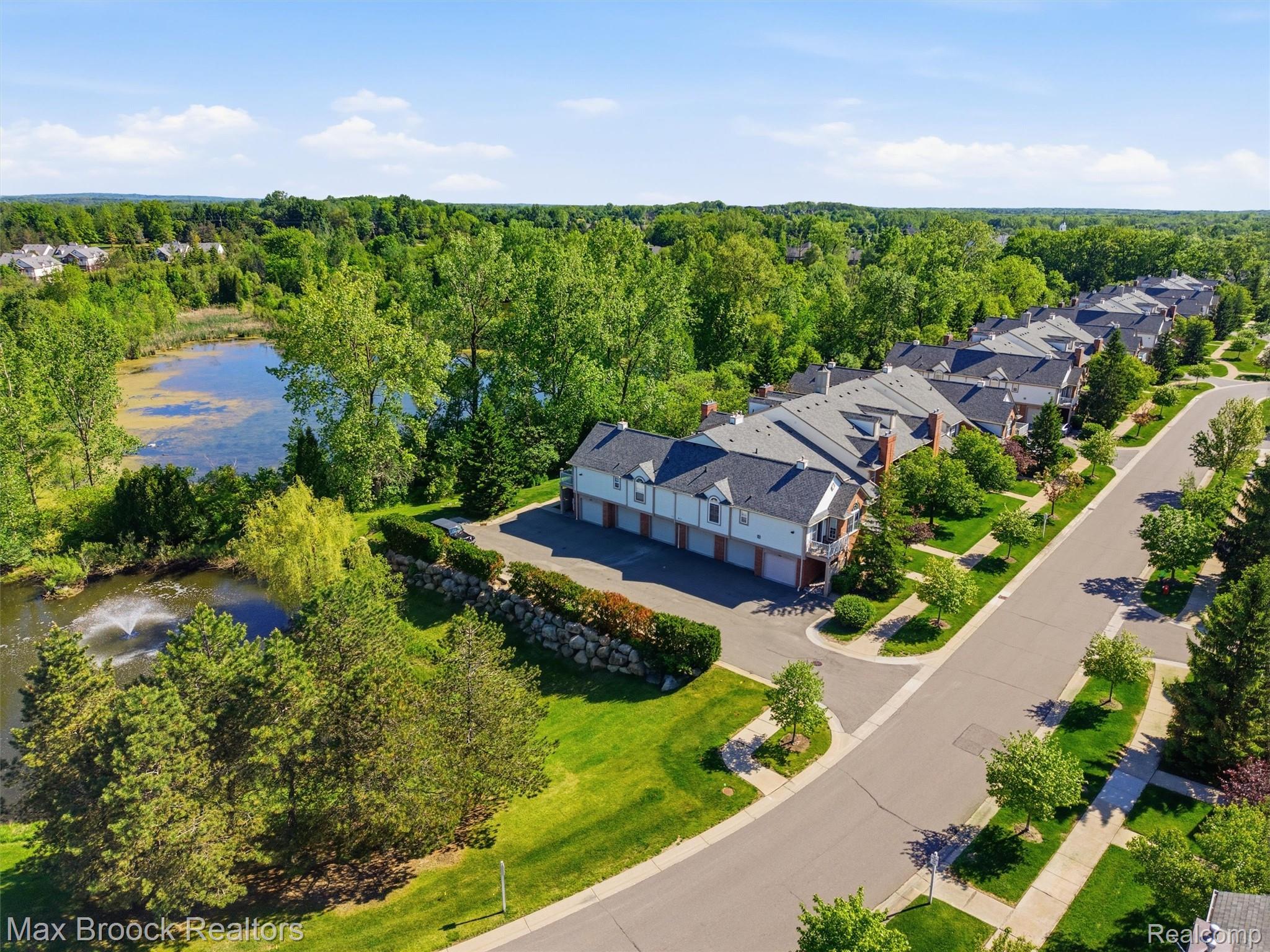 3562 Tremonte Circle Rochester, MI 48306 - Photo 3 of 33 Townhome community featuring a private pond with a fountain, mature landscaping, and a paved street with sidewalks