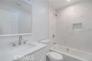 a bathroom with a bathtub shower sink vanity and toilet