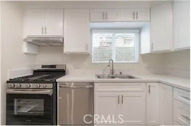 a kitchen with white cabinets and appliances