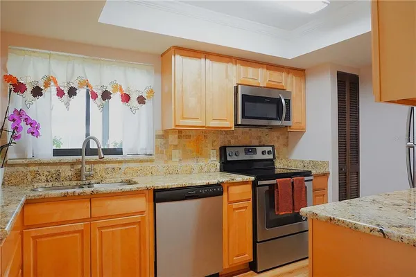 a kitchen with stainless steel appliances granite countertop a refrigerator stove and microwave