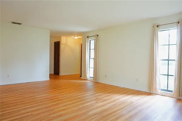 a dining room with furniture a chandelier and wooden floor