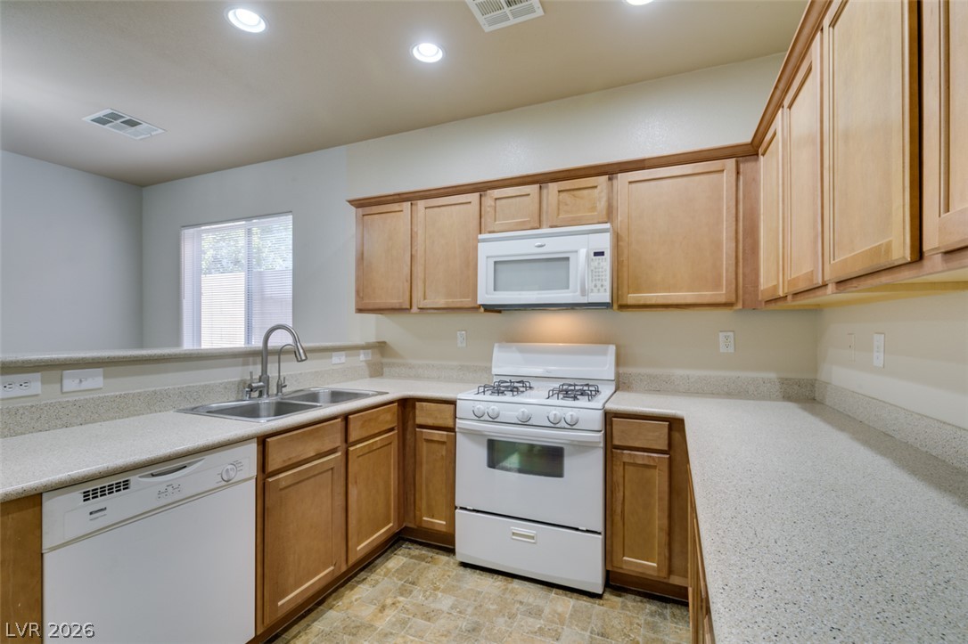 8937 Caledon Ridge Court Las Vegas, NV 89149 - Photo 24 of 43 A well-appointed kitchen features ample counter space and natural wood cabinetry.