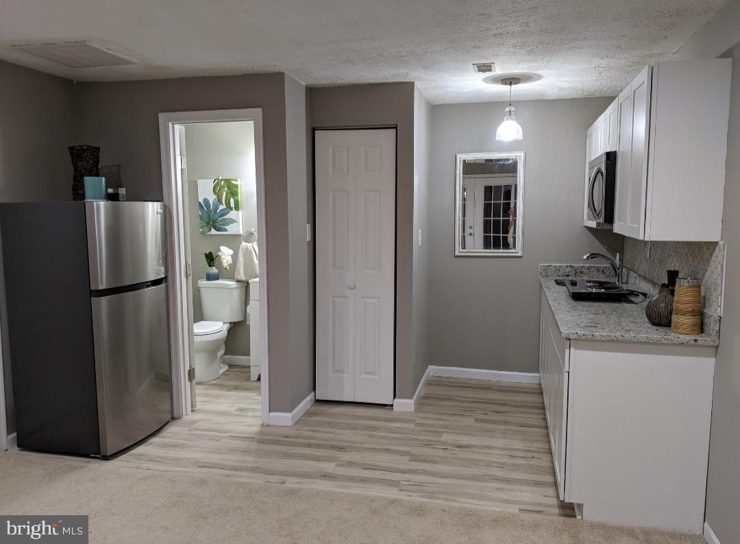 4657 Deepwood Court, Unit 106A Bowie, MD 20720 - Photo 18 of 29 a kitchen with stainless steel appliances granite countertop a refrigerator and a stove