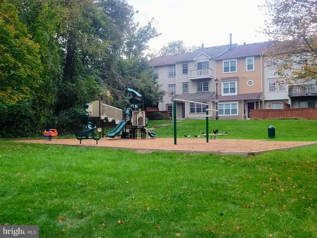 a view of a big house with a big yard and large trees