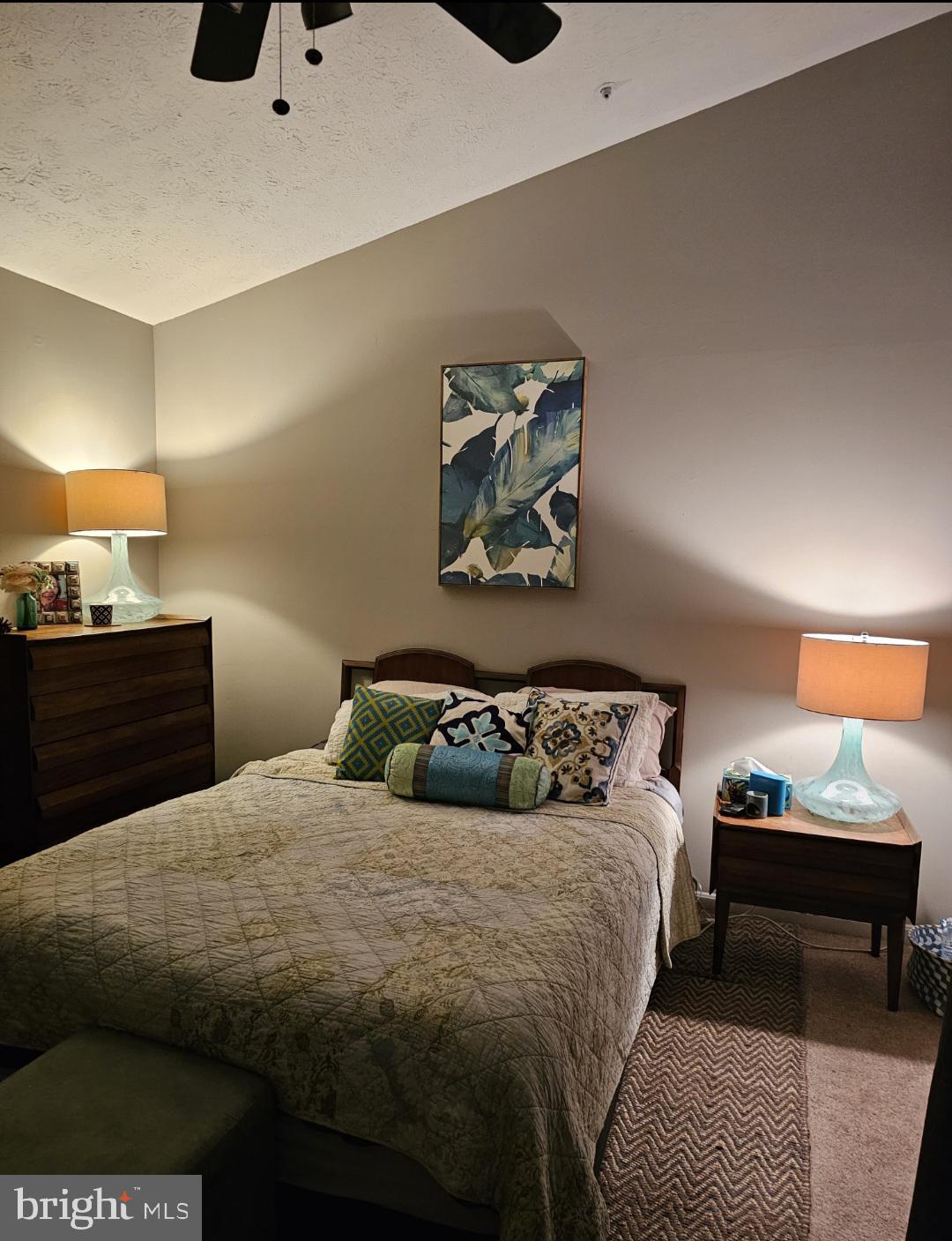 4657 Deepwood Court, Unit 106A Bowie, MD 20720 - Photo 4 of 29 a bedroom with a bed and a lamp on dresser