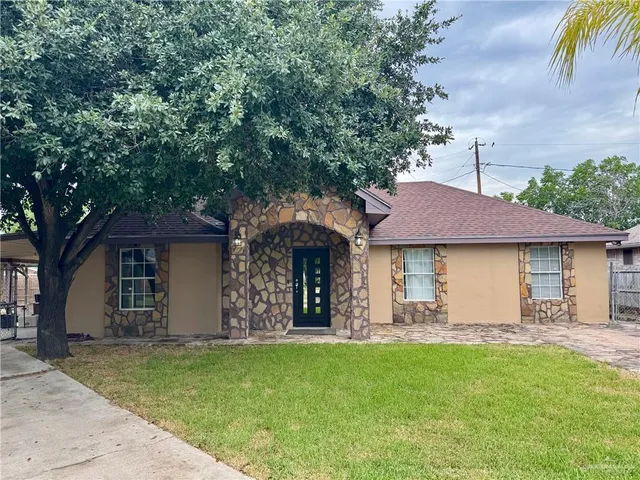 a view of a house with yard and a tree